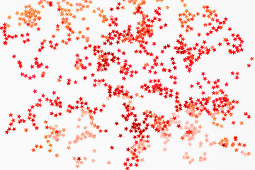 Holiday background with red and orange star confetti. Good background for Christmas and New Year cards.