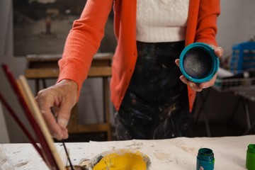 Mid section of woman painting bowl