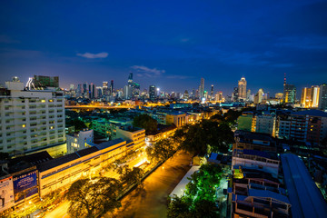 Naklejka na ściany i meble Bangkok cityscape skyline, Thailand. Modern tower and local building, express way, road and vehicle, and train station at twilight evening
