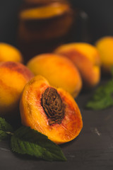 Jar of peach iced tea with fresh peaches on the rustic background. Shallow depth of field. Toned image.