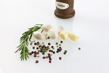 Garlic (Allium sativum) with pepper mill, fresh rosemary, black and red pepper