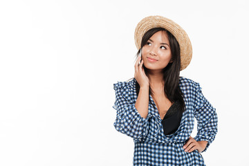Portrait of a smiling asian woman in dress and hat