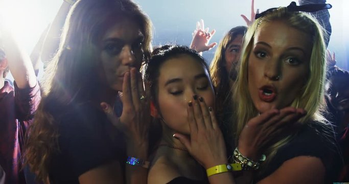 Group of women giving flying kiss at a concert 