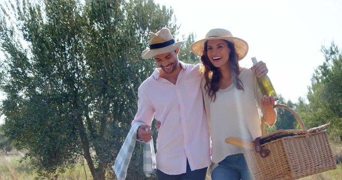 Romantic couple walking with wicker basket in olive farm 