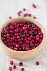 fresh cranberries on white wooden surface