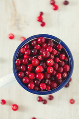 fresh cranberries on white wooden surface