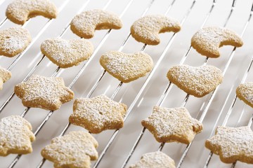 Shortcrust cookies on oven grid, dusted with powdered sugar