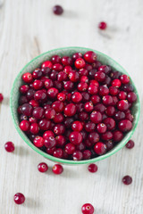 fresh cranberries on white wooden surface