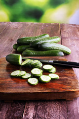 Fresh and sliced cucumbers. Sliced cucumbers on a cutting board.