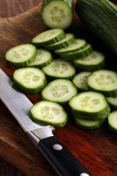 Fresh and sliced cucumbers. Sliced cucumbers on a cutting board.