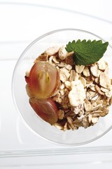 Muesli with grapes in a glass bowl