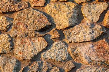 Fragment of sunlit stone wall