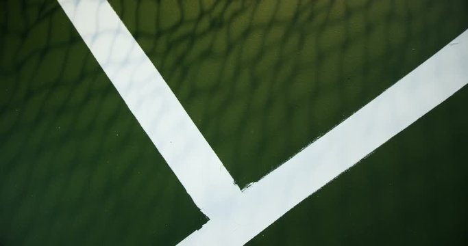 Tennis ball bouncing on white line in court 