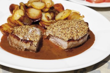 Young roast pork with mustard crust and baked potatoes