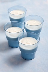 Four blue cups of yoghurt