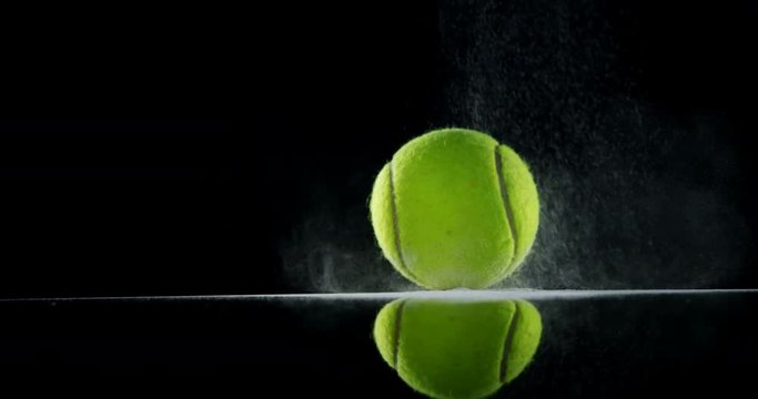 Bouncing ball with powder against black background 