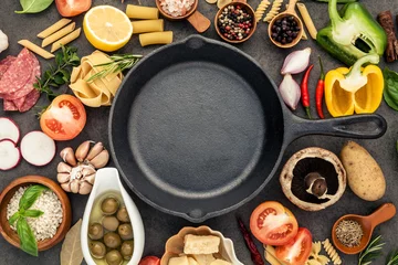 Papier Peint photo Cuisinier Italian food cooking ingredients on dark stone background with  cast iron pan flat lay and copy space.