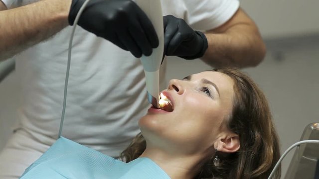 Dentist scanning the teeth of patient with a d scanner