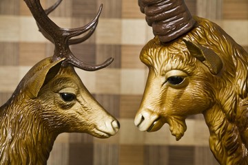 Head of a deer and the head of an ibex, plastic, gazing longingly into each others eyes