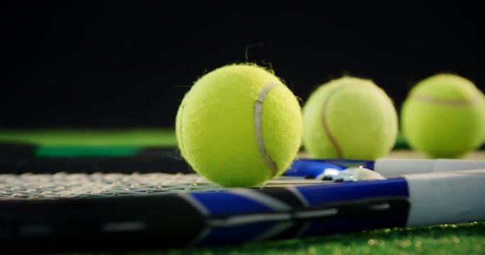 Tennis balls and racket in court 