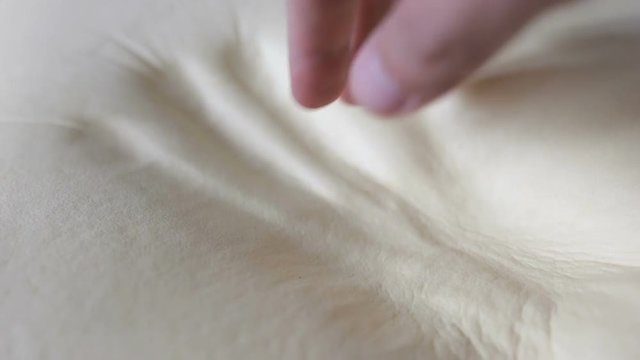 Mano sta toccando un materasso in memory foam spugna tecnologica per dormire comodi.