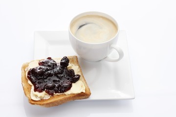 Porcelain plate with a cup of coffee and toast with cherry jam