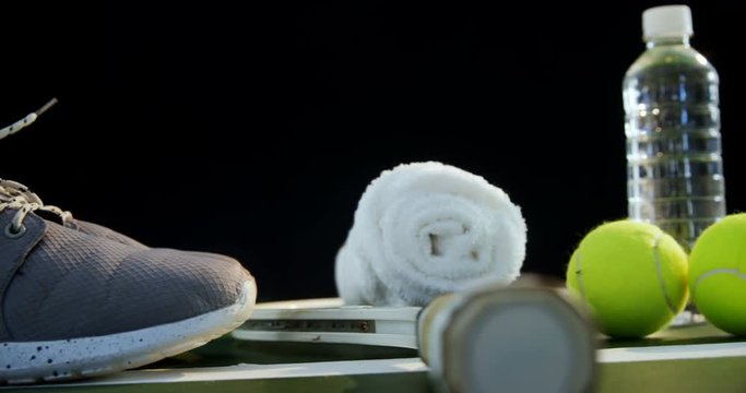 Water bottle, sports shoes and sports equipment in tennis court 