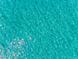 Aerial top view of sea surface. Transparent turquoise ocean water surface from drone.