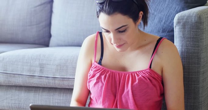 Beautiful woman using laptop in living room 