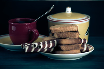 waffle rolls on a plate coffee mug on a dark background