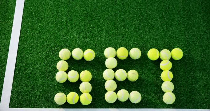 Tennis balls forming word set in court 