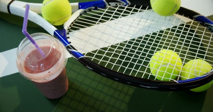 Milkshake and sports equipment in tennis court 