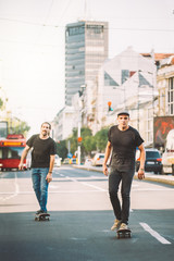 Two pro skateboard rider ride skate through cars on street