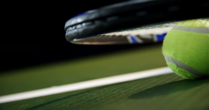 Racket and tennis ball in court 