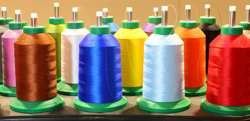 many colorful spools of thread in dressmaking factory