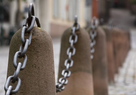 Stone bollard with steel chain on a small access road in Heidelberg, Baden-Wuerttemberg, Germany, Europe