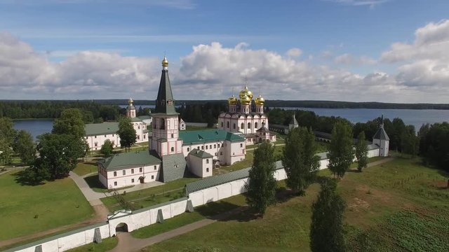 Cathedral of Our Lady of the Iberian Valday Iversky Russian Orthodox Monastery. Lake Seliger. Flight forward close aerial drone. Beautiful nature summer clouds horizon.