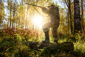 Un chasseur avec une arme à feu dans la forêt à l& 39 aube.