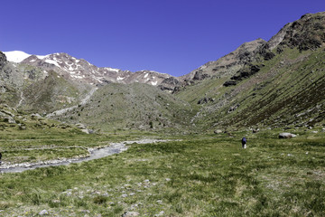 A man walking along a river in Adamello Brenta park