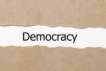 Fototapeta na wymiar Democracy word written under torn paper.