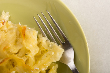 Gratinated macaroni with cheese served on the green plate