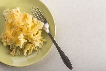 Crisp macaroni with cheese grated in the oven, served on the plate above white marble background