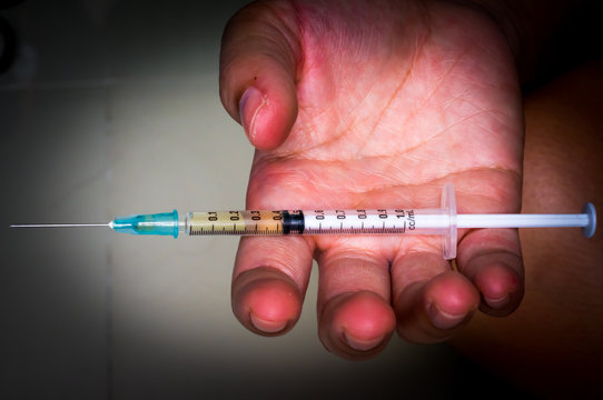 Hand of who addicted to drug holding syringe for injection.Drug abuse concept.