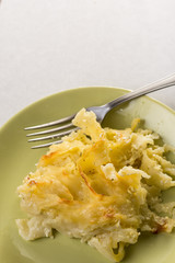 Gratinated macaroni with cheese served on the green plate