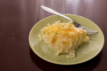 Crisp macaroni with cheese grated in the oven, served on the plate above white marble background