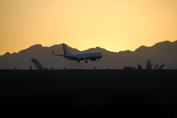 Fototapeta na wymiar The plane landed at sunset on a background of mountains