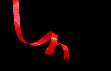 Red ribbon isolated on black background.