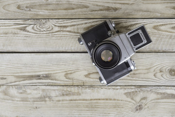 Old vintage film camera on wooden background. the view from the top.