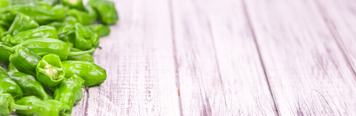 Wooden table with Raw Pimientos, selective focus