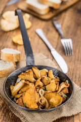 Fried Chanterelles on wooden background; selective focus